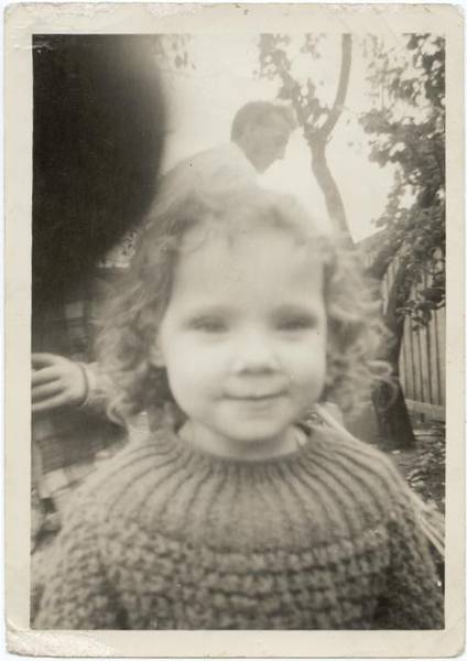 Donna in garden with father in background